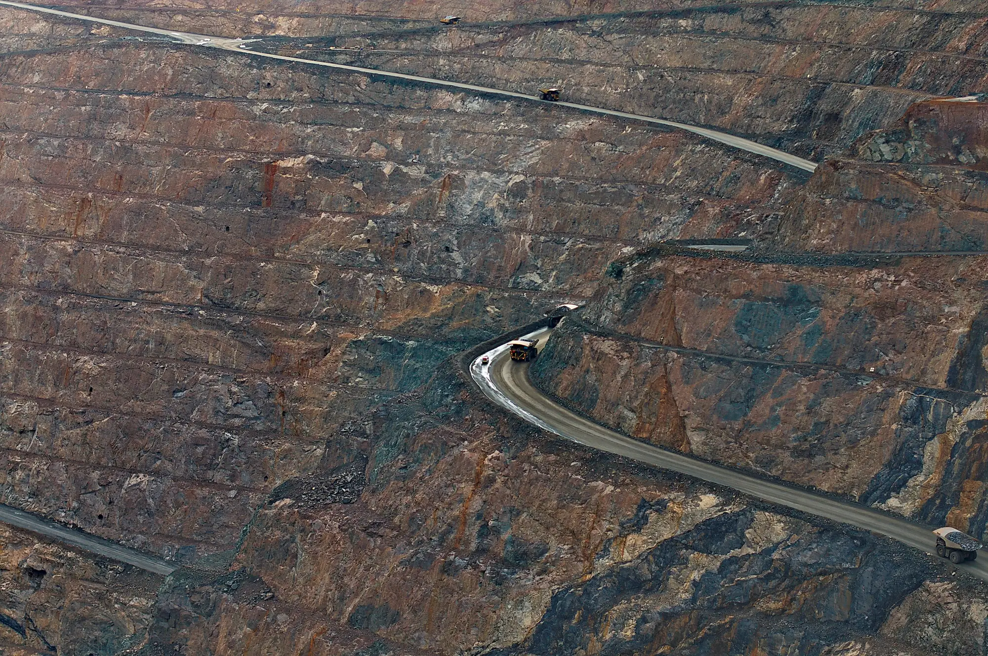 A haul road switching back across the benched wall of an open pit